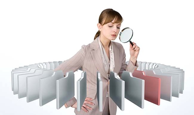 Businesswoman holding magnifying glass, close-up